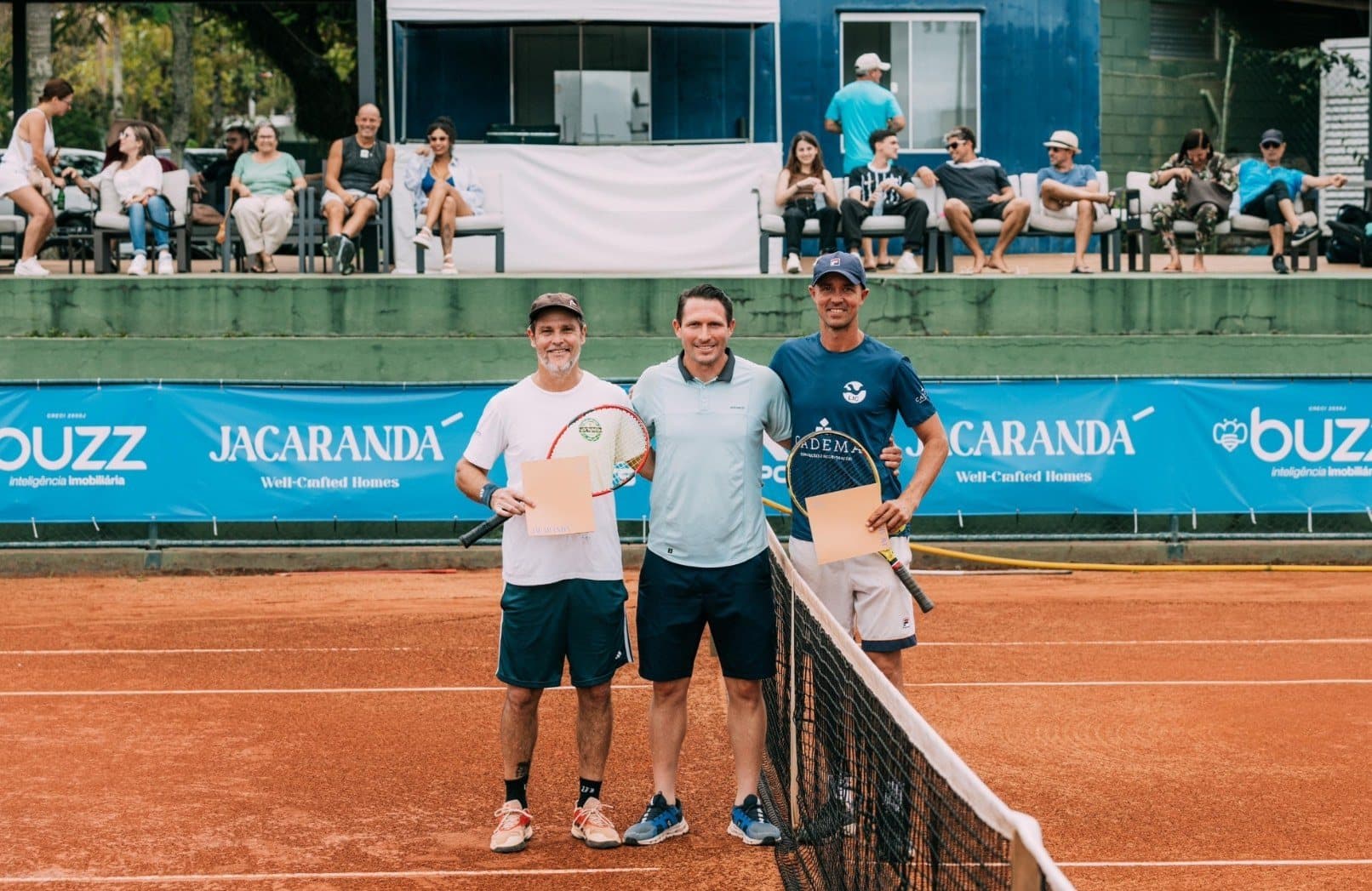 Finalistas posando junto à rede com o público ao fundo